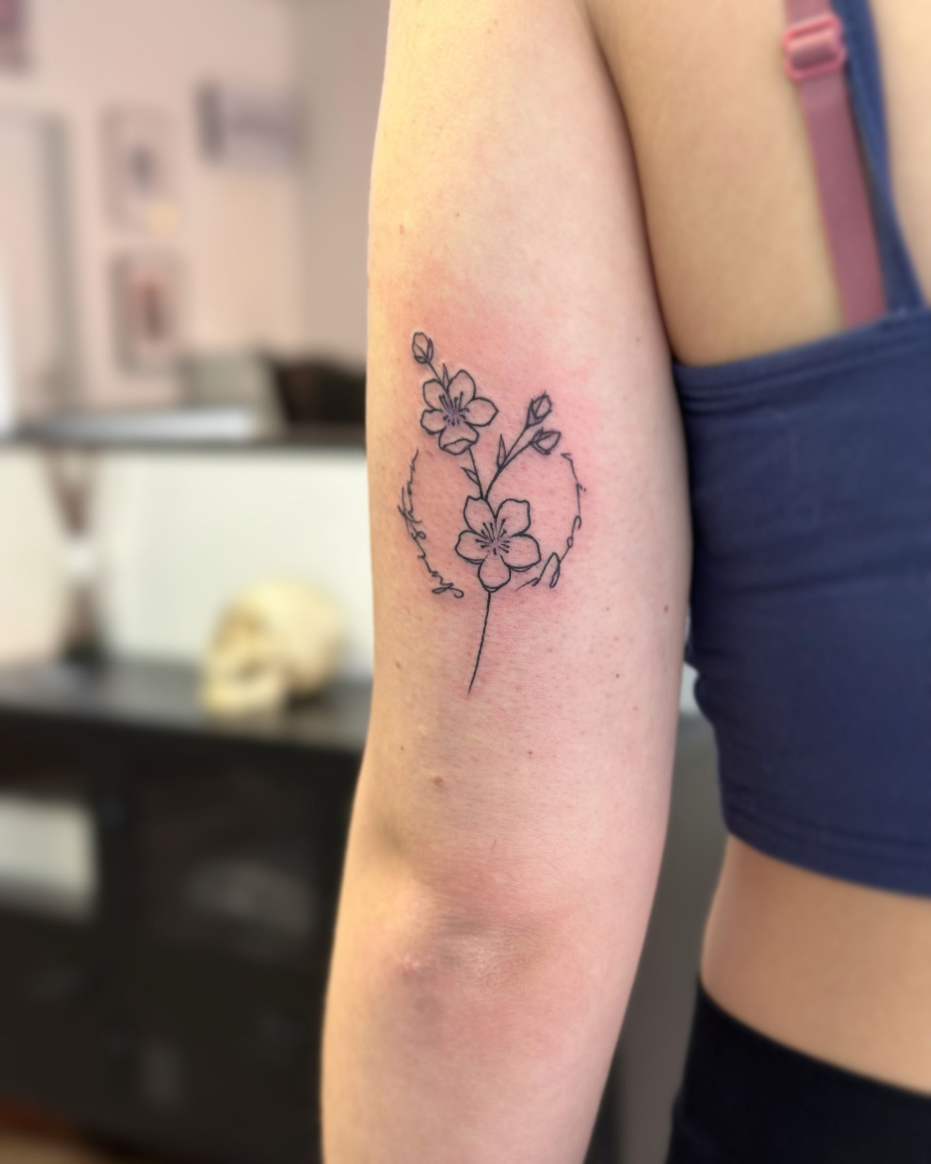 Eine Frau hat eine Tätowierung einer Blume auf ihrem Arm