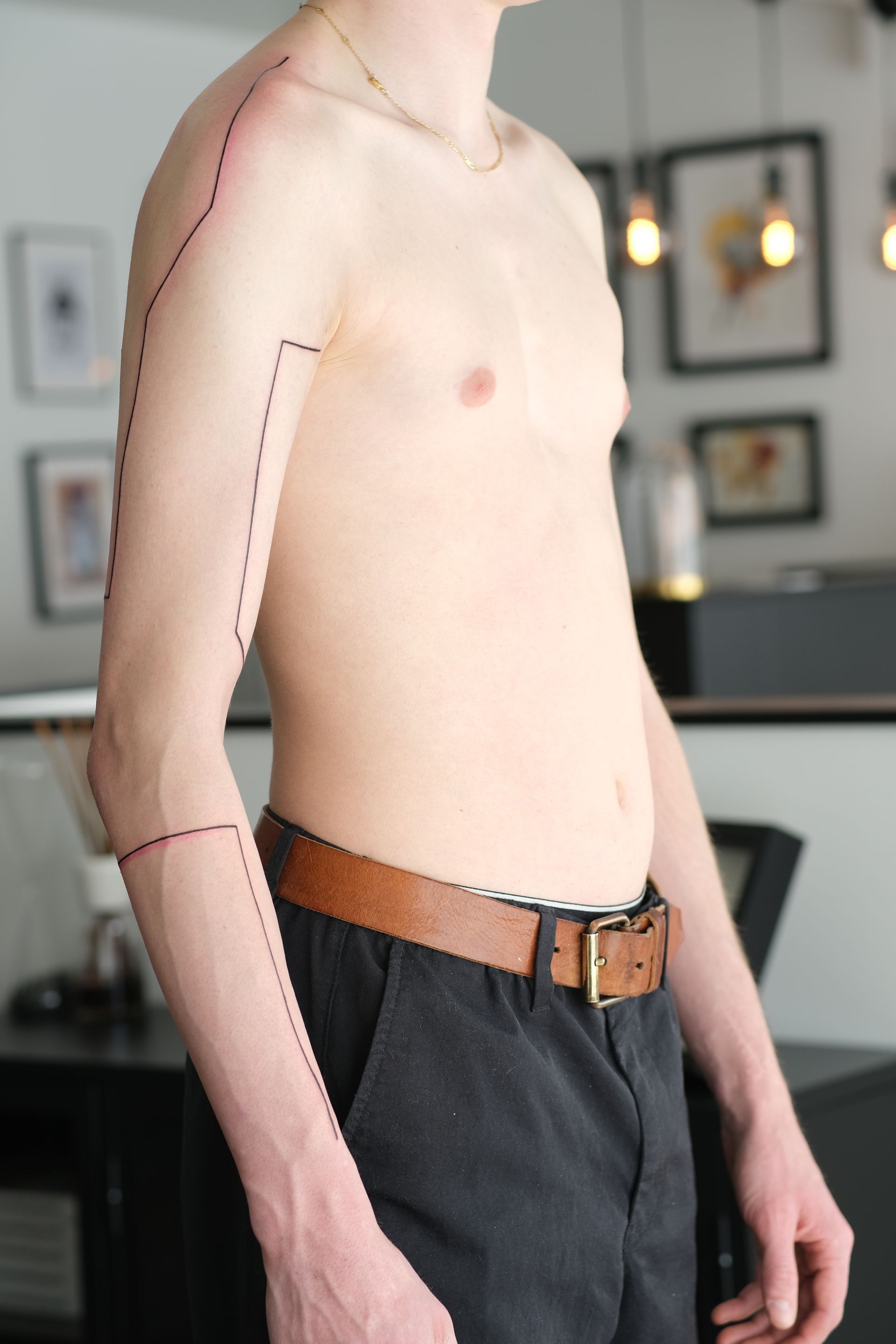 Ein Mann ohne Hemd hat eine Linie auf seinem Arm