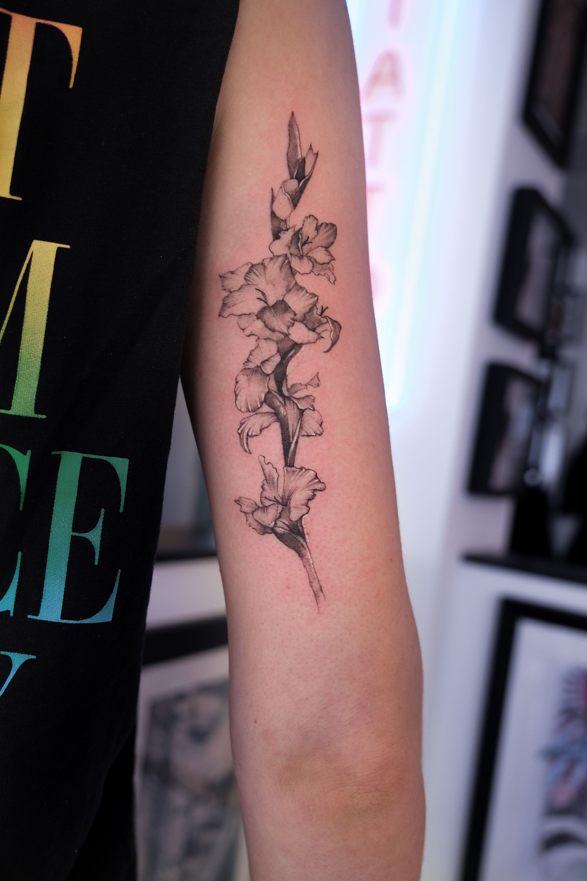 Eine Person hat eine Tätowierung einer Blume auf dem Arm