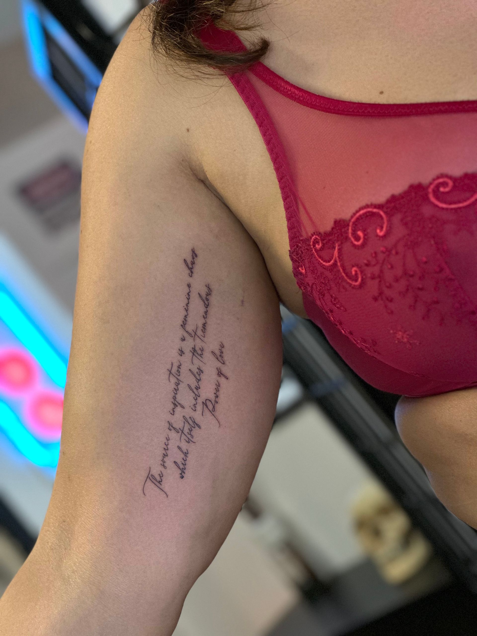 Eine Frau in einem roten BH hat eine Tätowierung auf ihrem Arm