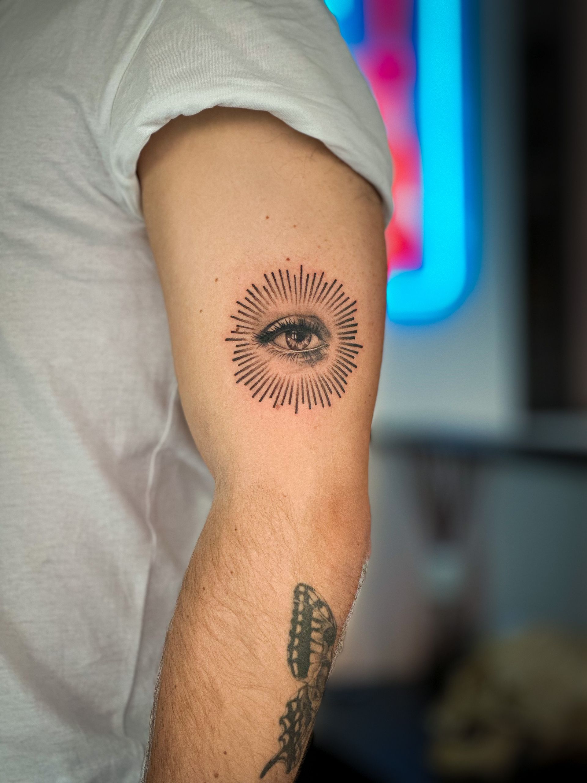 Ein Mann hat eine Augentätowierung auf seinem Arm.