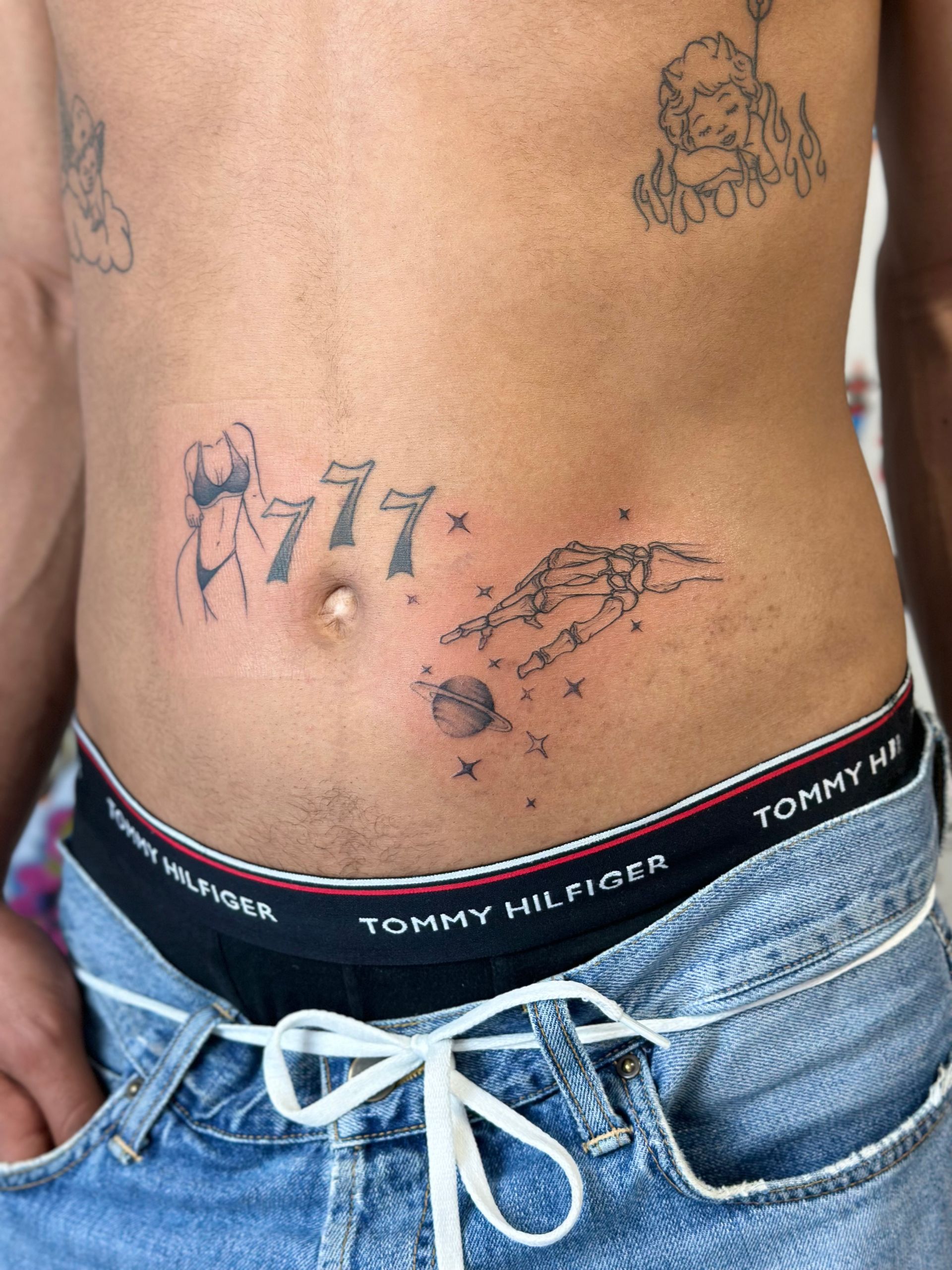 Ein Mann mit einer Tätowierung auf dem Bauch trägt Unterwäsche von Tommy Hilfiger.