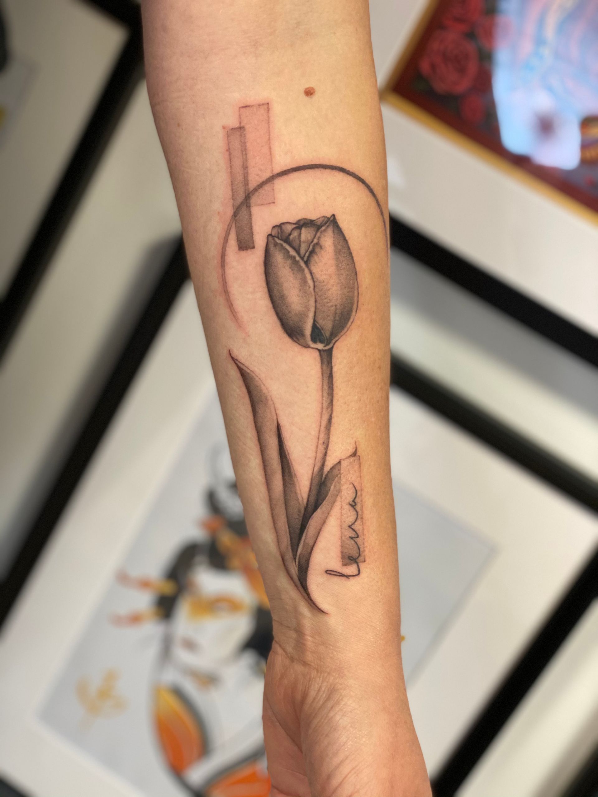 Eine Frau hat eine Tätowierung einer Tulpe auf ihrem Unterarm