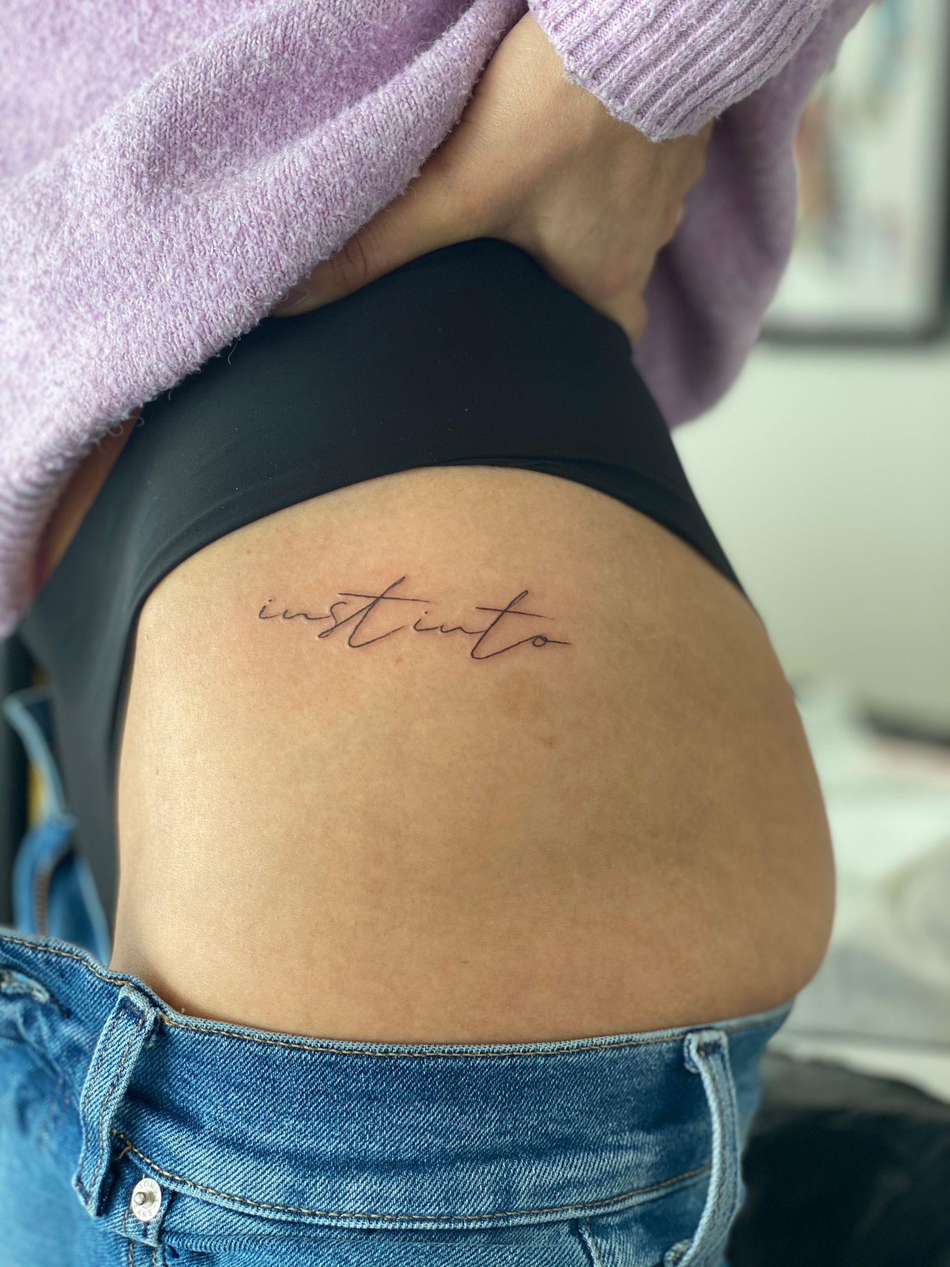 Eine Frau hat eine kleine Tätowierung auf ihrer Hüfte.