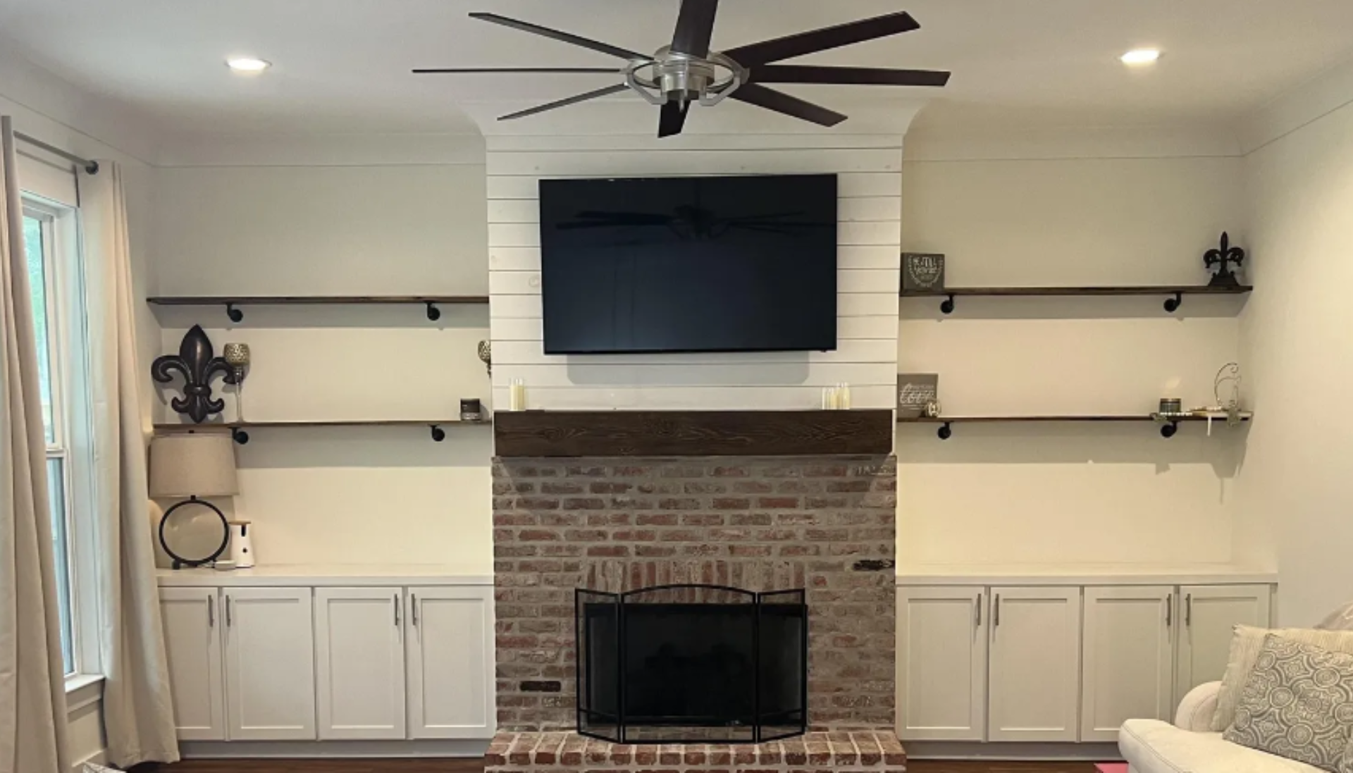 A living room with a fireplace and a flat screen tv on the wall.