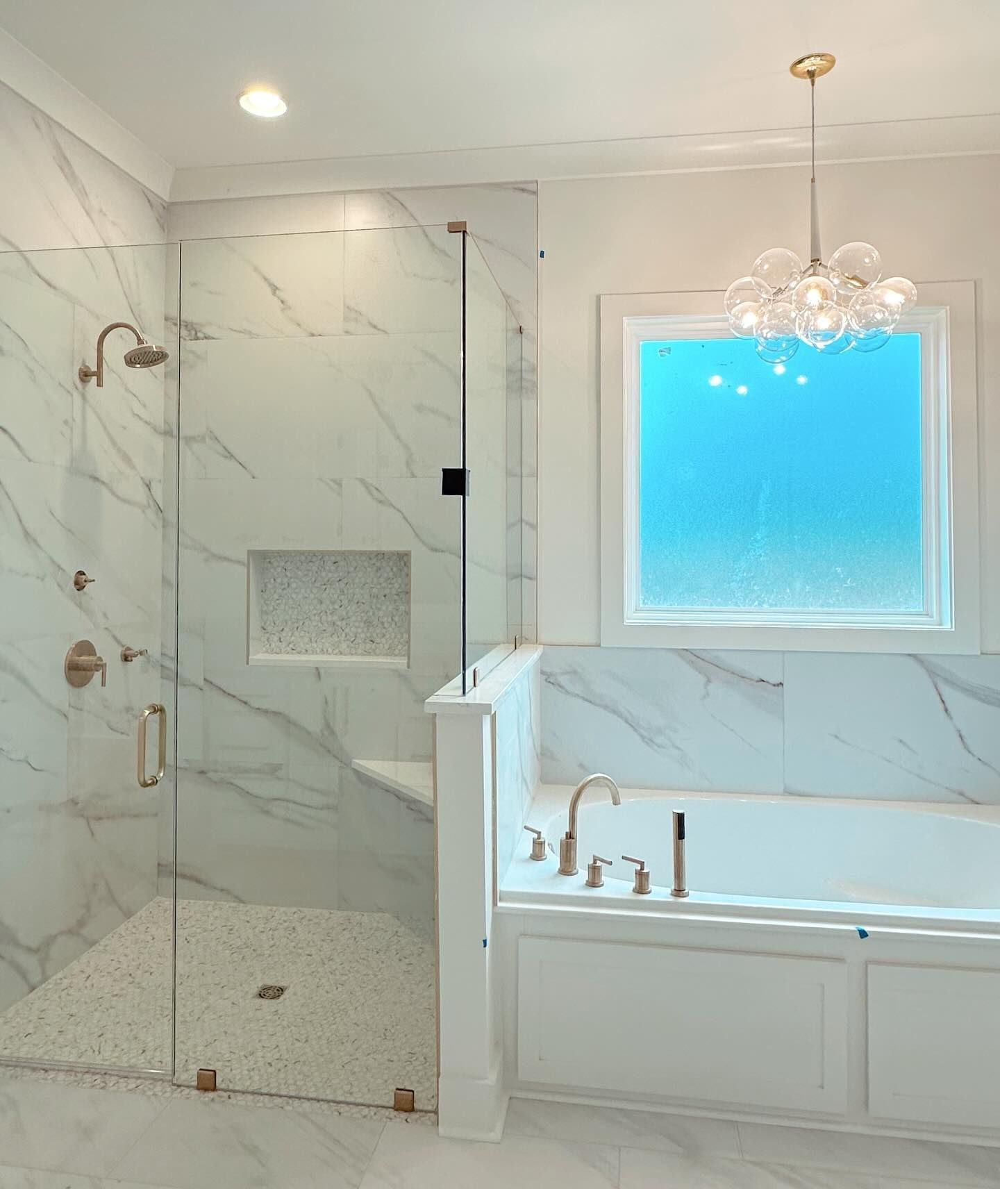 A bathroom with a tub , shower and window