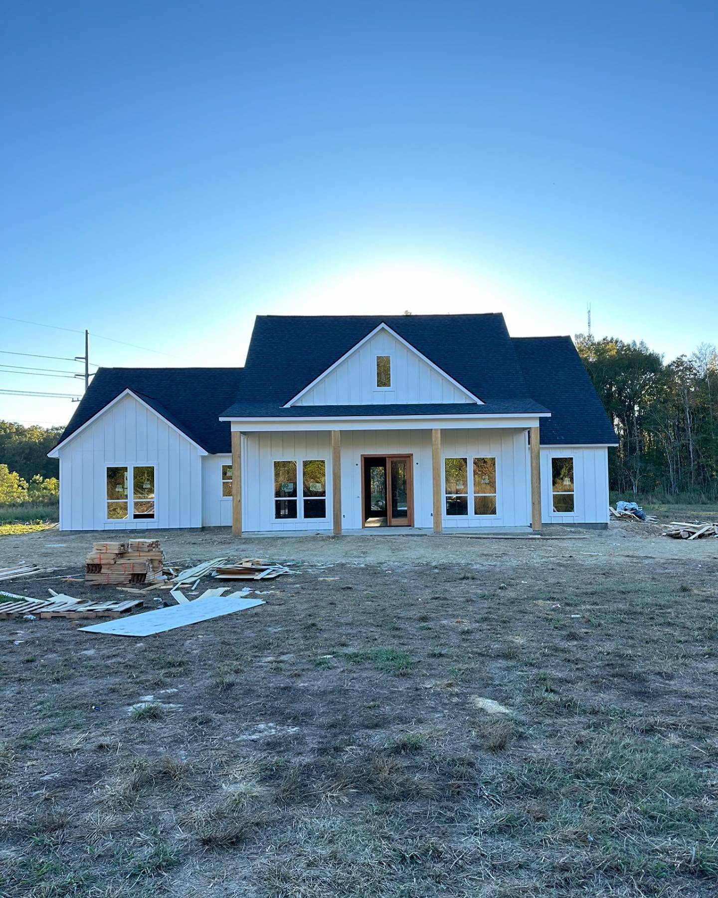 A white house with a blue roof is sitting in the middle of a field.