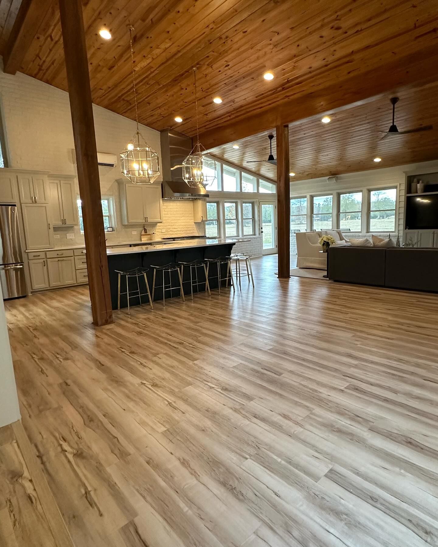 A large living room with hardwood floors and a wooden ceiling.