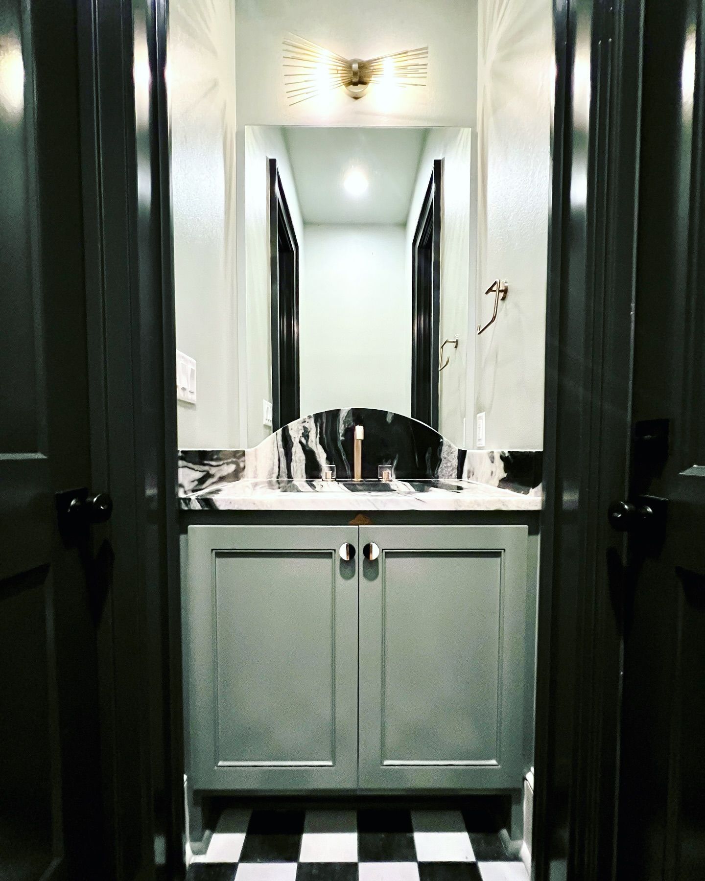 A bathroom with a sink and a checkered floor