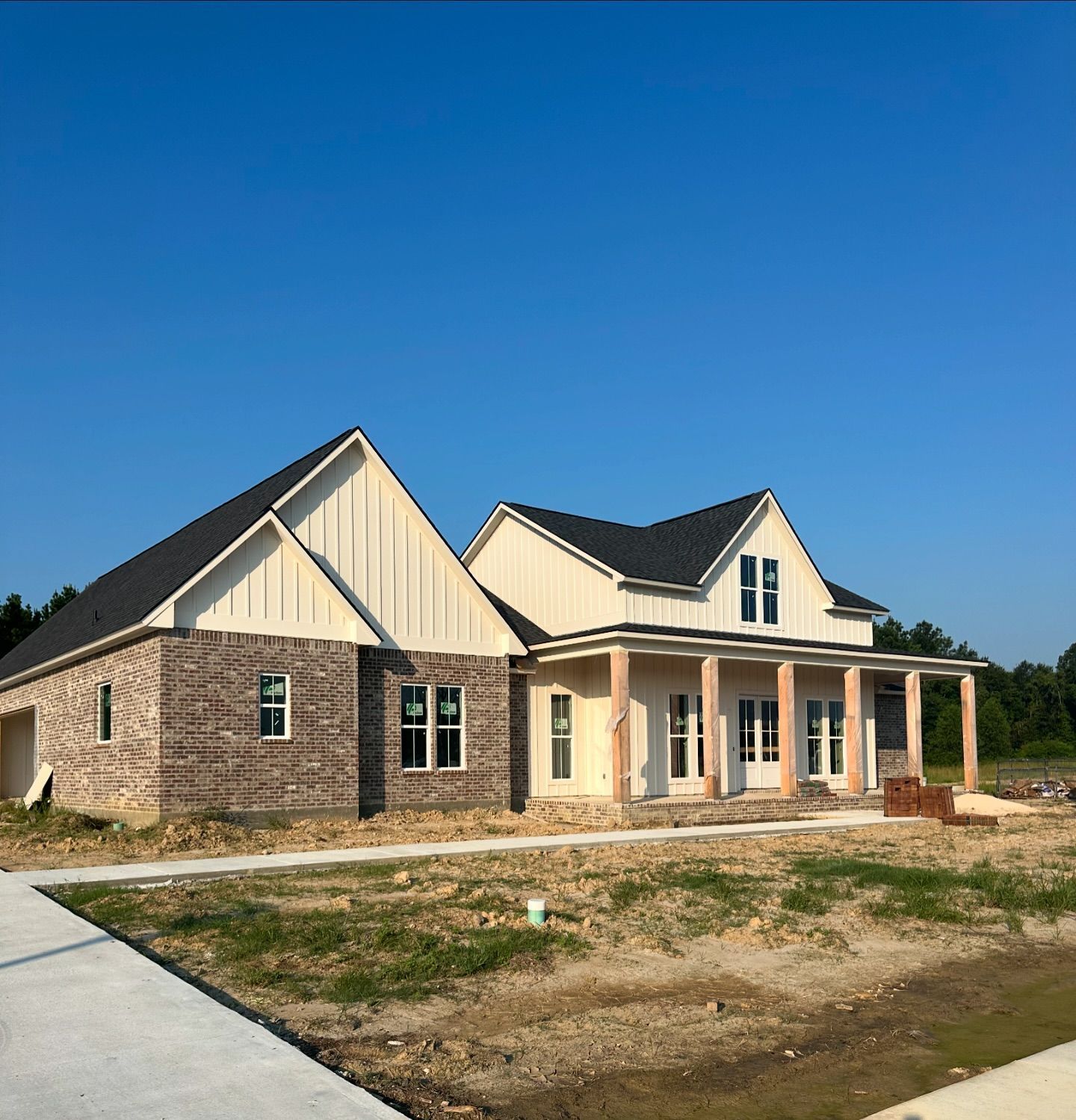 A brick house with a porch and a blue sky in the background