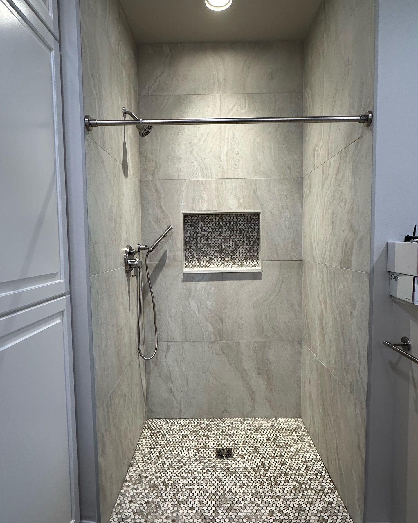 A bathroom with a walk in shower and a sink.