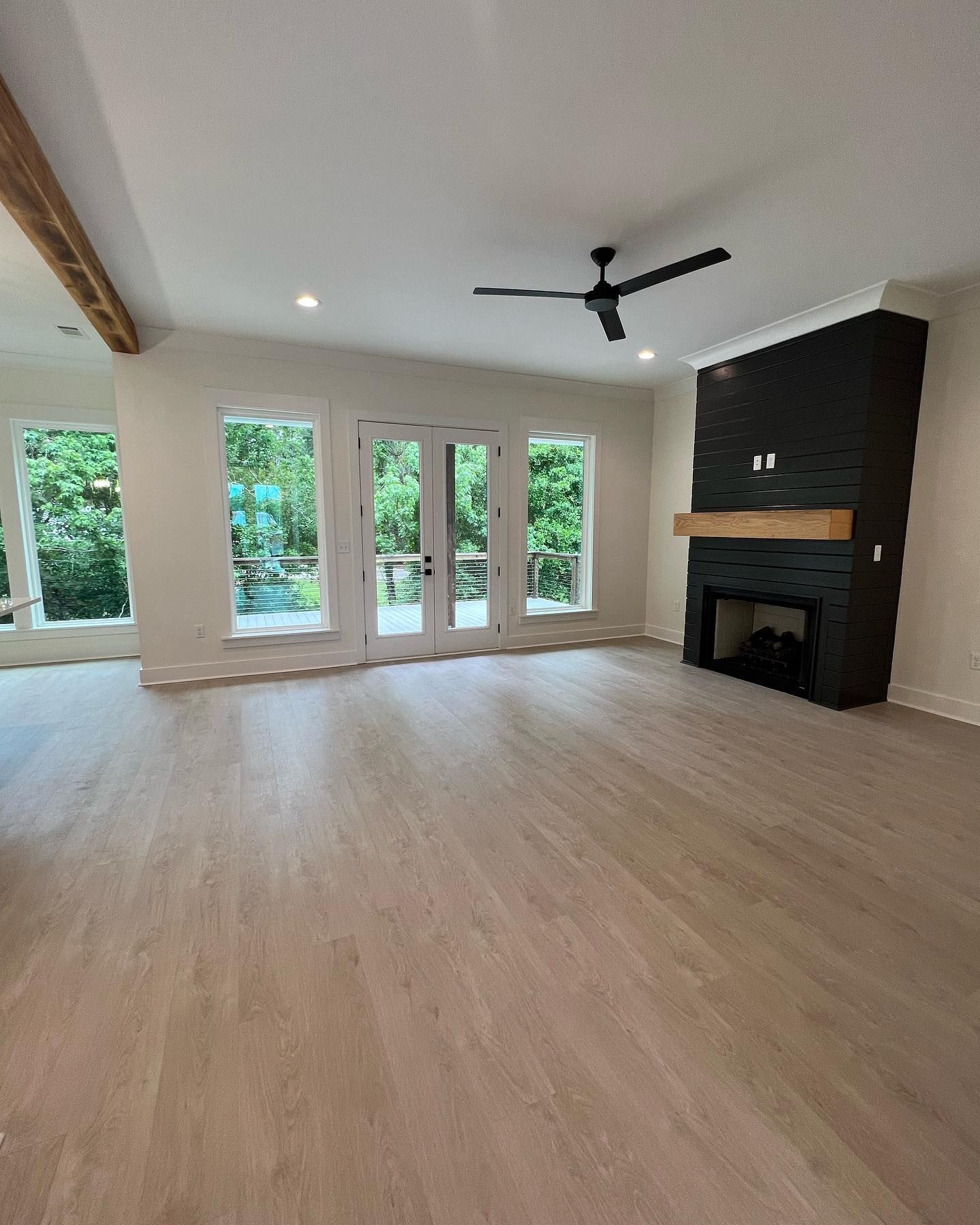 An empty living room with a fireplace and a ceiling fan.