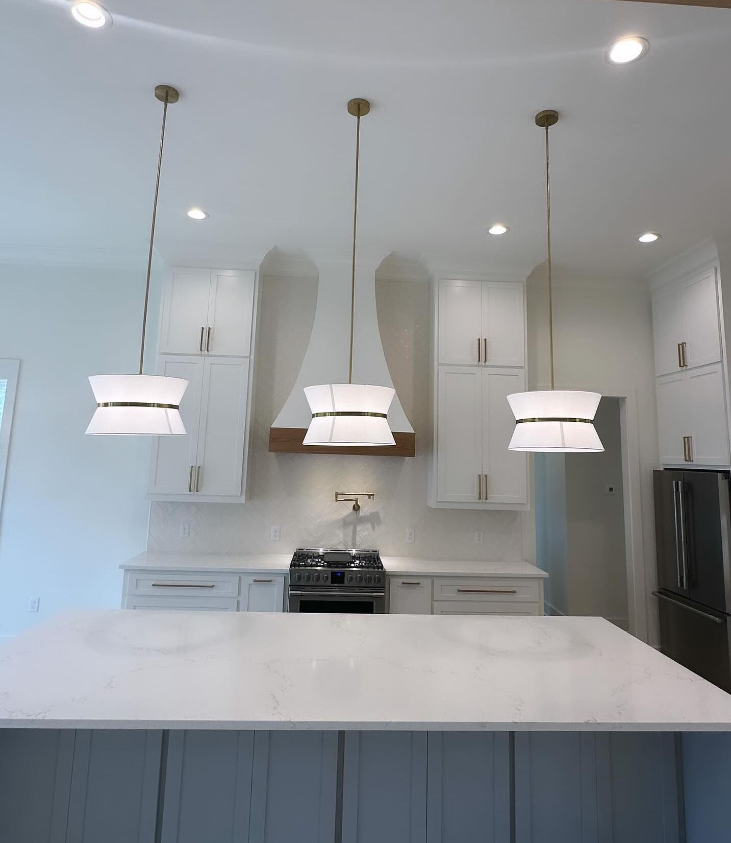 A kitchen with white cabinets and a stove top oven