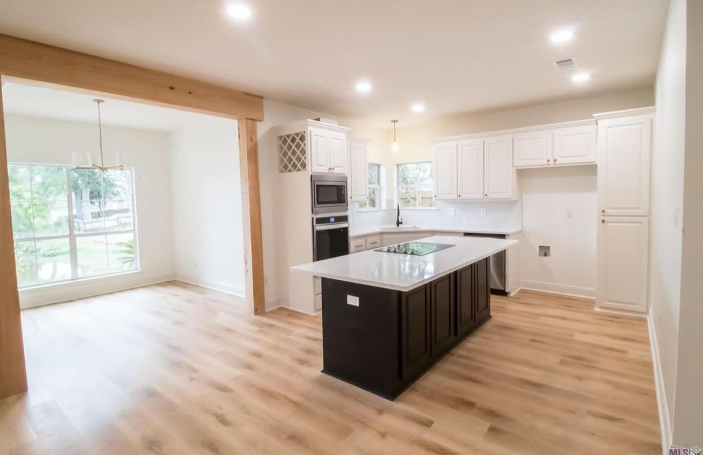 A walk in closet with lots of shelves and a large island in the middle.