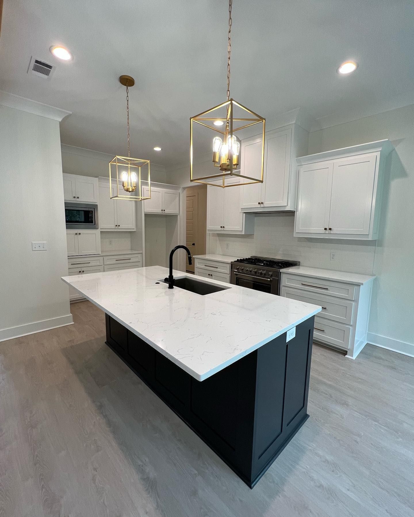 A kitchen with white cabinets and a large island in the middle.