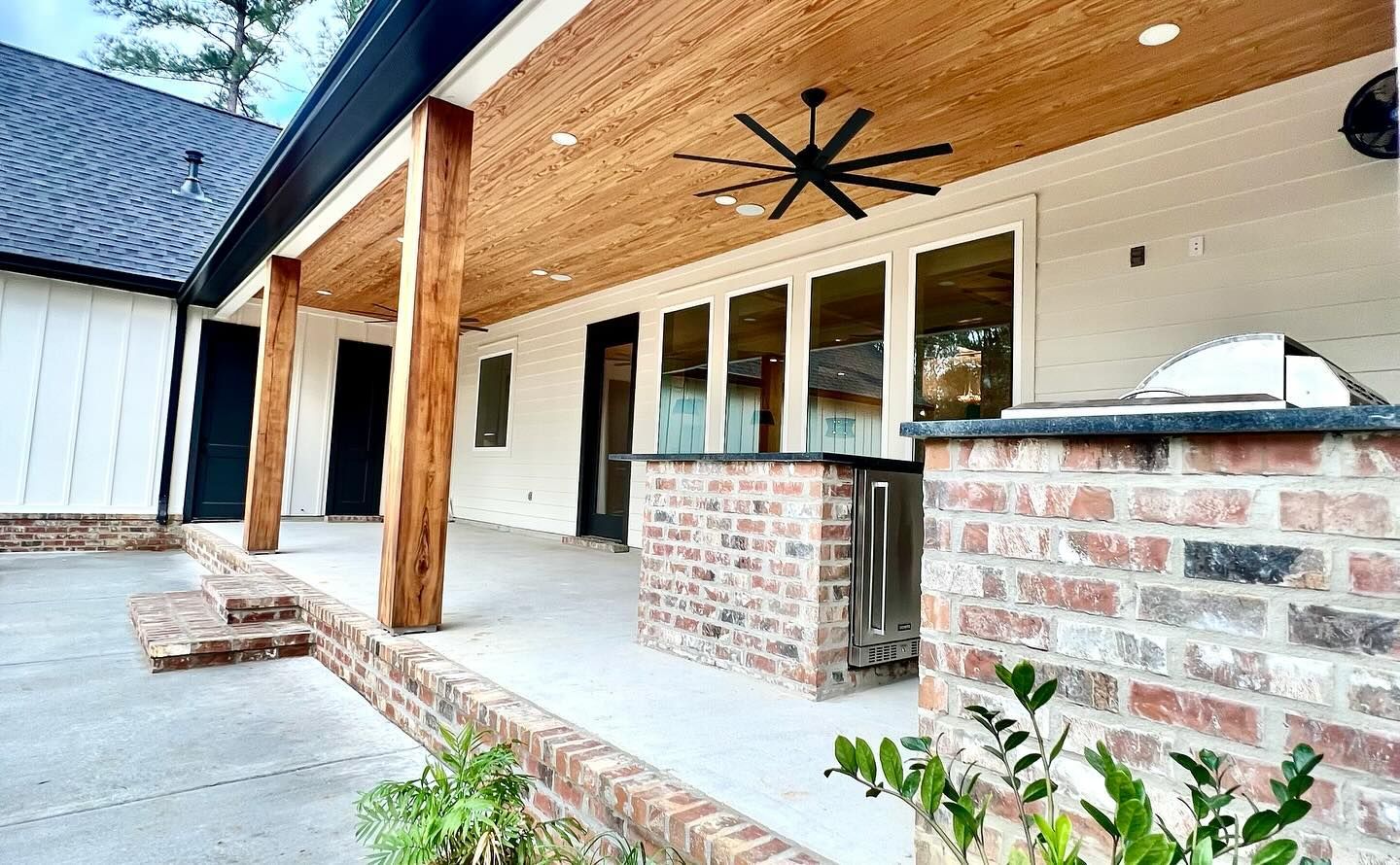 There is a ceiling fan on the porch of a house.