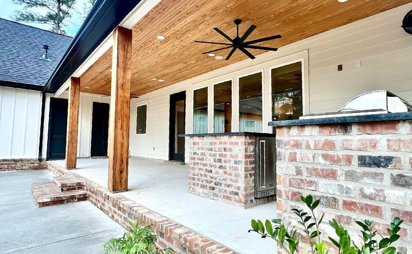 There is a ceiling fan on the porch of a house.