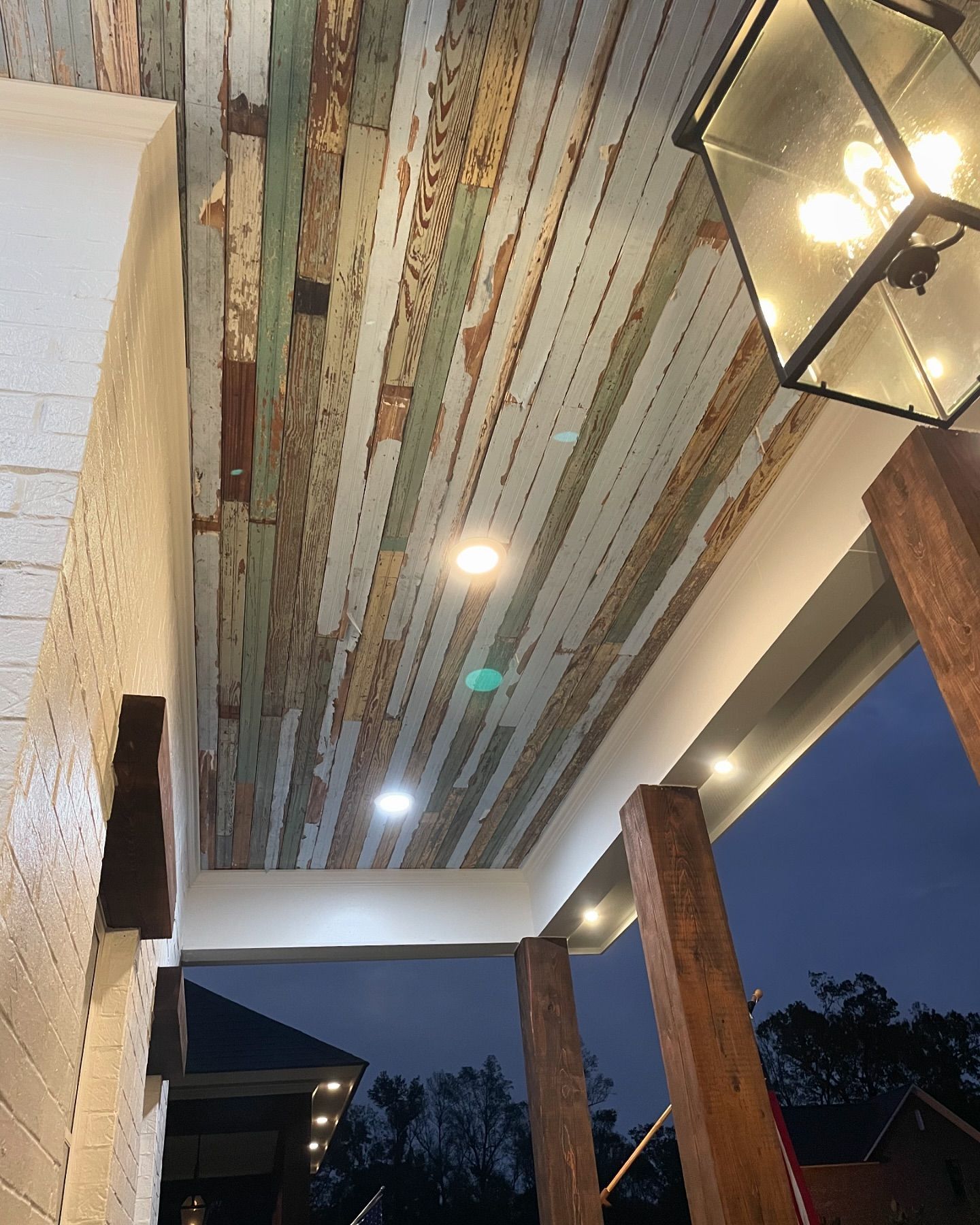 A porch with a wooden ceiling and a lantern