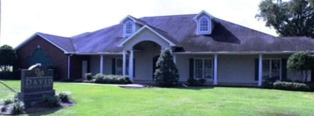 A large house with a sign in front of it that says david