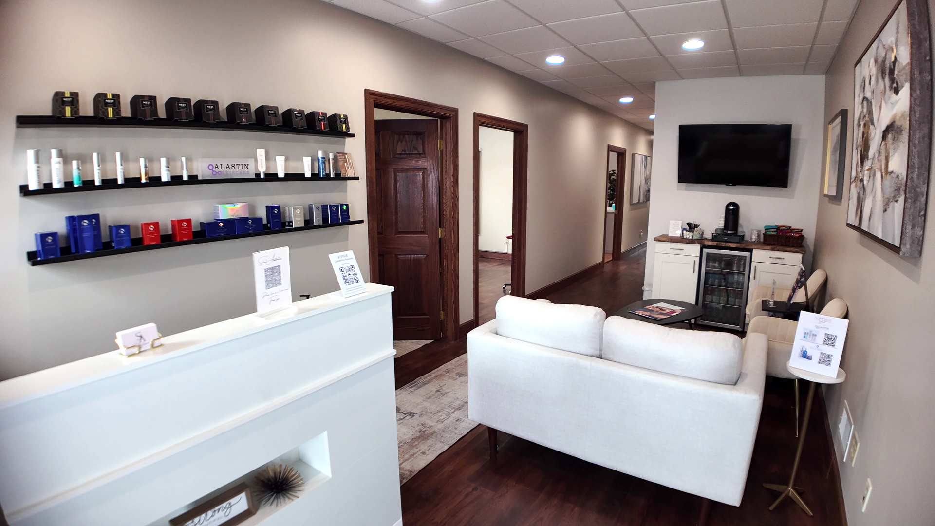 Reception area with white sofa, products on shelves, and artwork.
