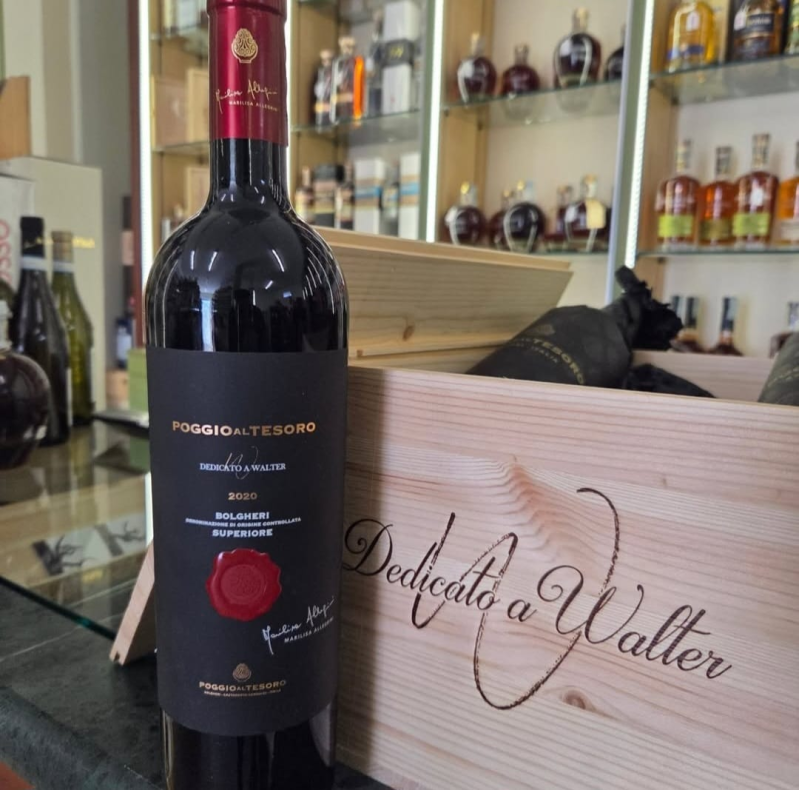 Bottiglia di vino rosso davanti a una scatola di legno con l'etichetta