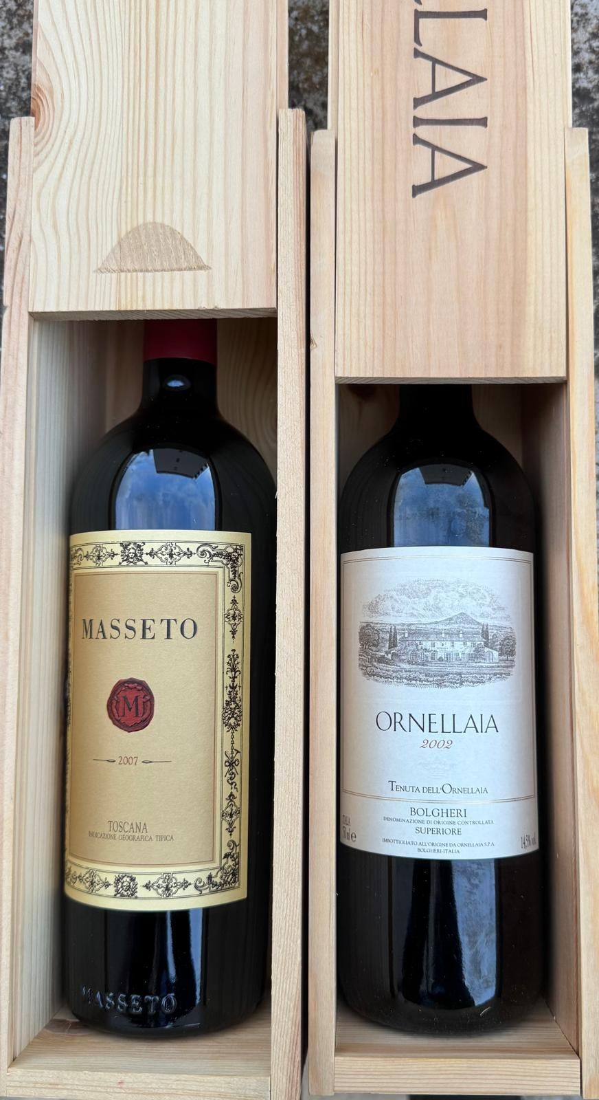 Due bottiglie di vino rosso in casse di legno. Etichette