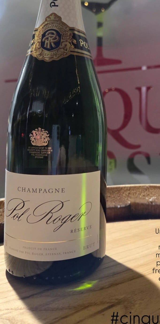 Una bottiglia di champagne Pol Roger su una superficie di legno.