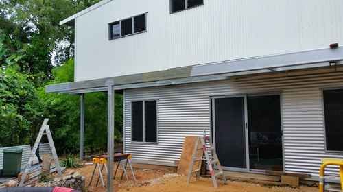 a white house with a metal roof is being built .