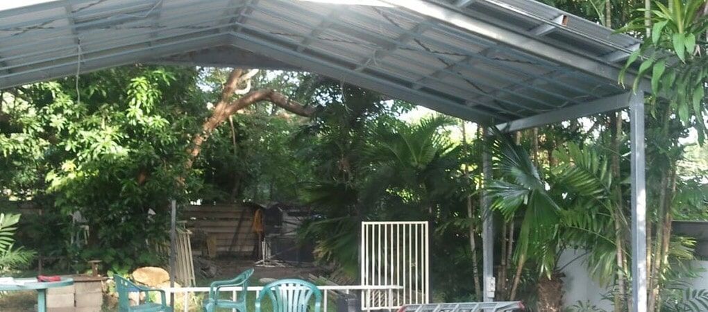 a covered area with a table and chairs under a roof