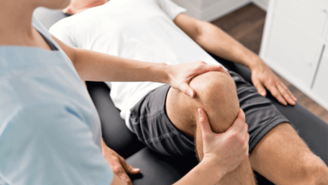 A man is getting his knee examined by a doctor.