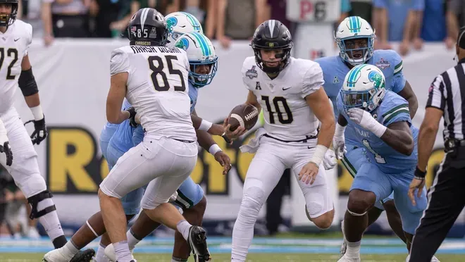 A group of football players are playing a game on a field.