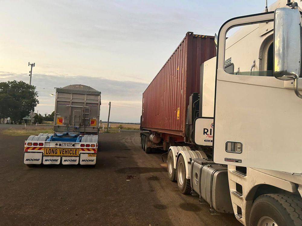 Two Semi Trucks Are Parked Next To Each Other in A Parking Lot — Ries Trucking in Gowrie Mountain, QLD