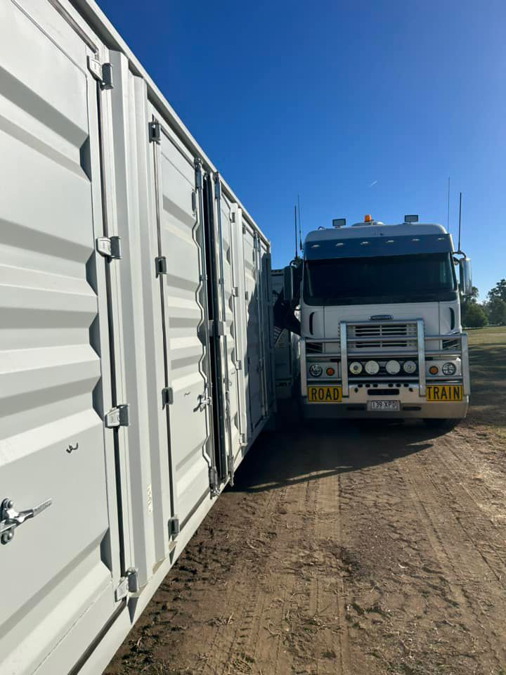 A Truck Is Parked Next To A Row Of Shipping Containers — Ries Trucking in Gowrie Mountain, QLD