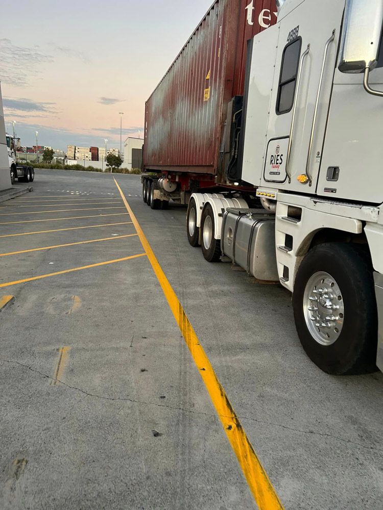 Two Semi Trucks Are Parked Next To Each Other In A Parking Lot — Ries Trucking in Gowrie Mountain, QLD