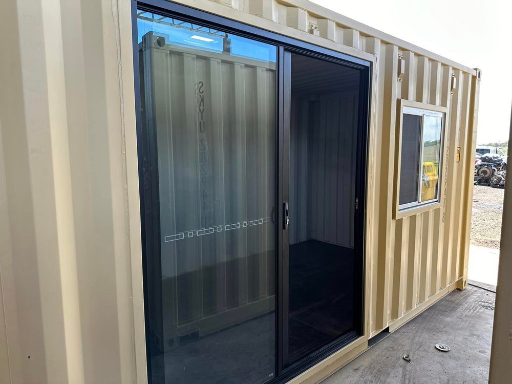 A Shipping Container With A Sliding Glass Door And A Window — Ries Trucking in Gowrie Mountain, QLD