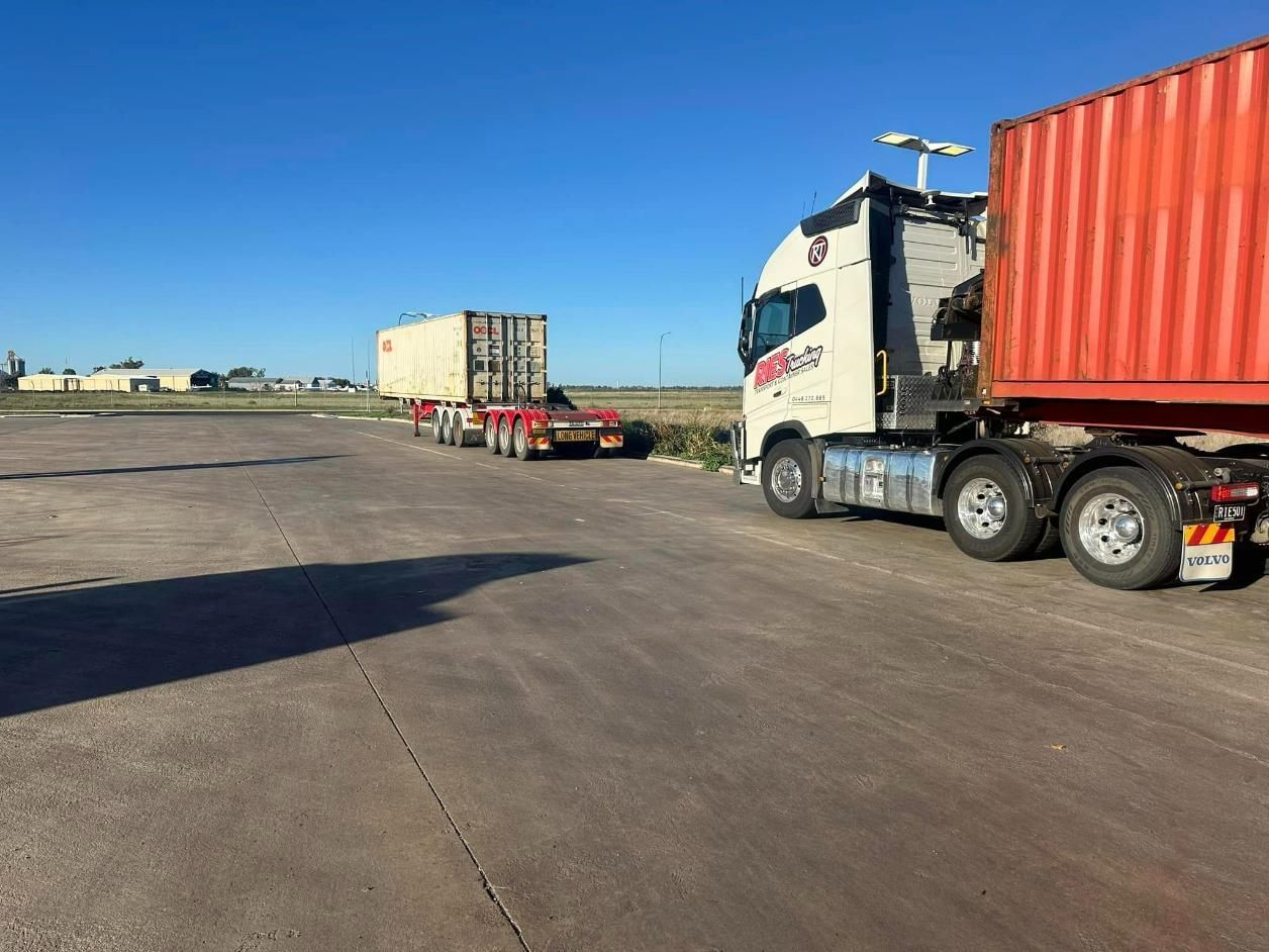 Two Semi Trucks Are Parked Next To Each Other In A Parking Lot — Ries Trucking in Millmerran, QLD