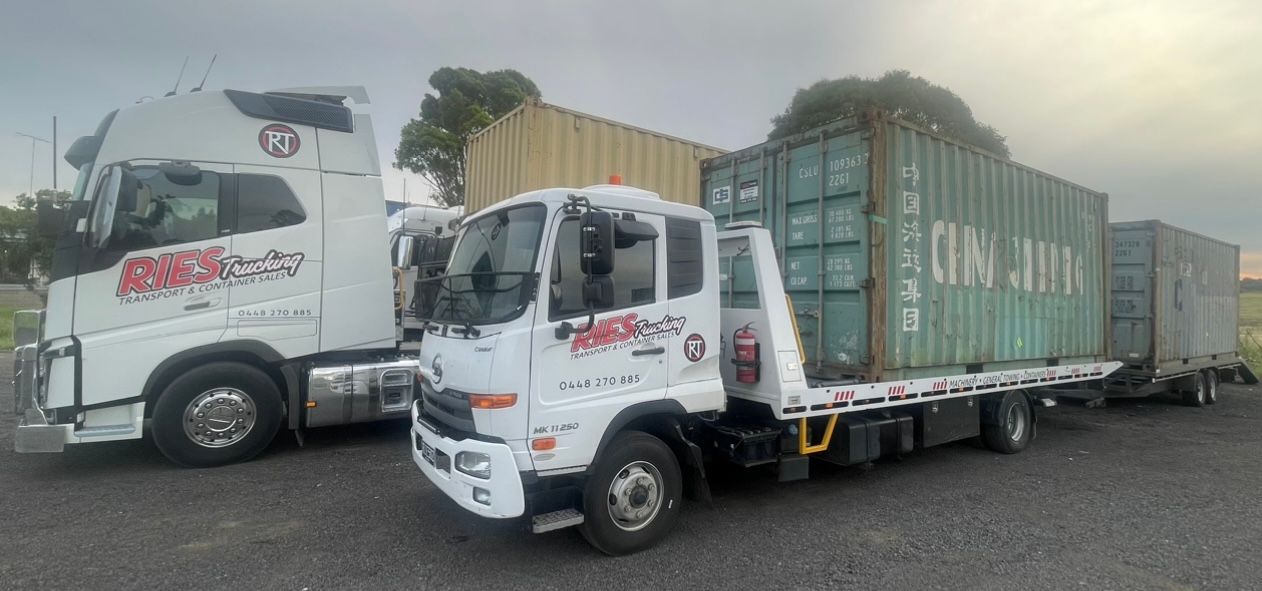 White Semi Truck Is Pulling A Green Shipping Container — Ries Trucking in Gowrie Mountain, QLD