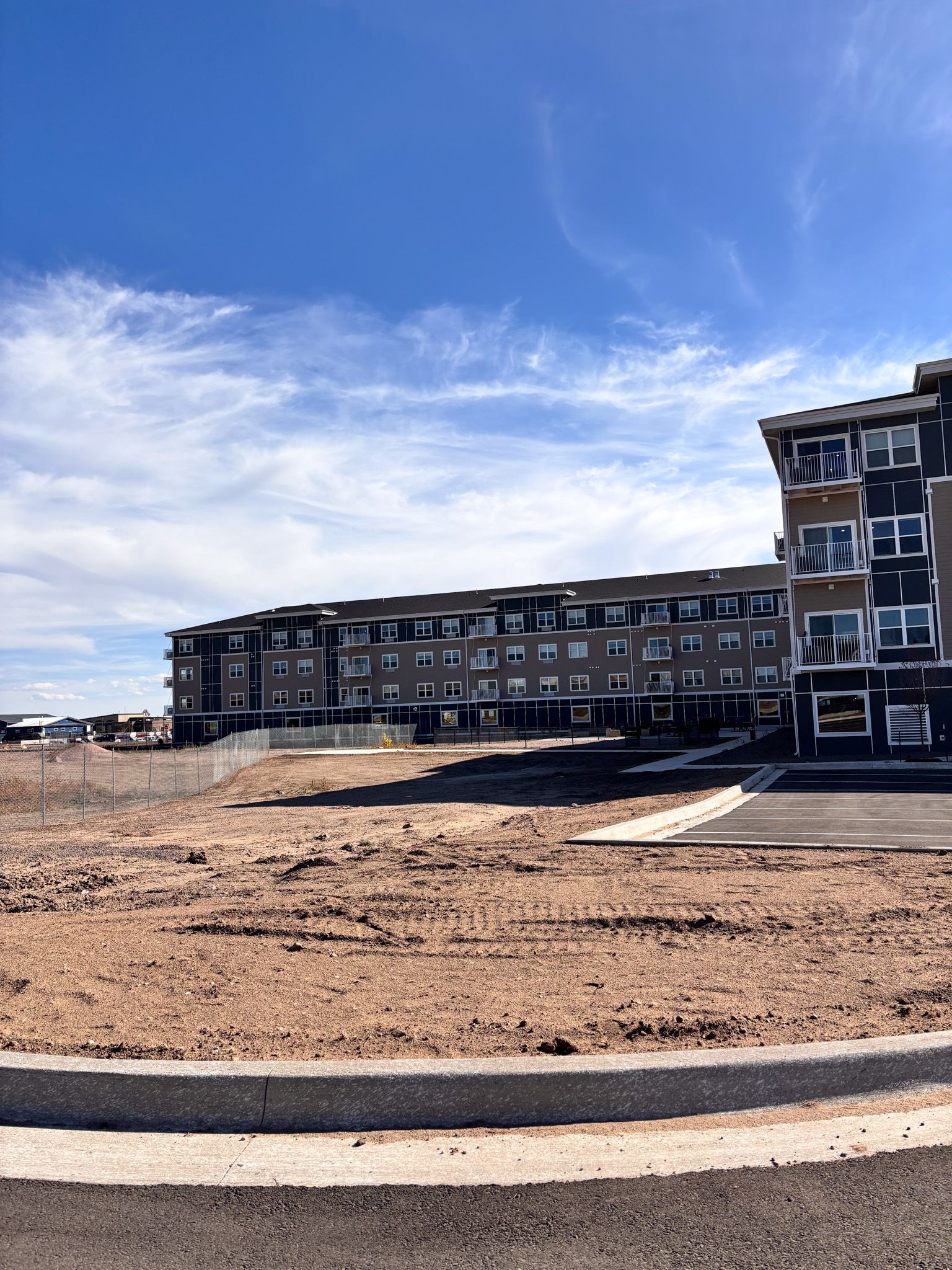 Modern apartment building under a blue sky with wispy clouds