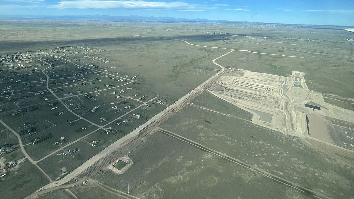Aerial view of a rural landscape with roads, scattered homes, and a runway or construction site.