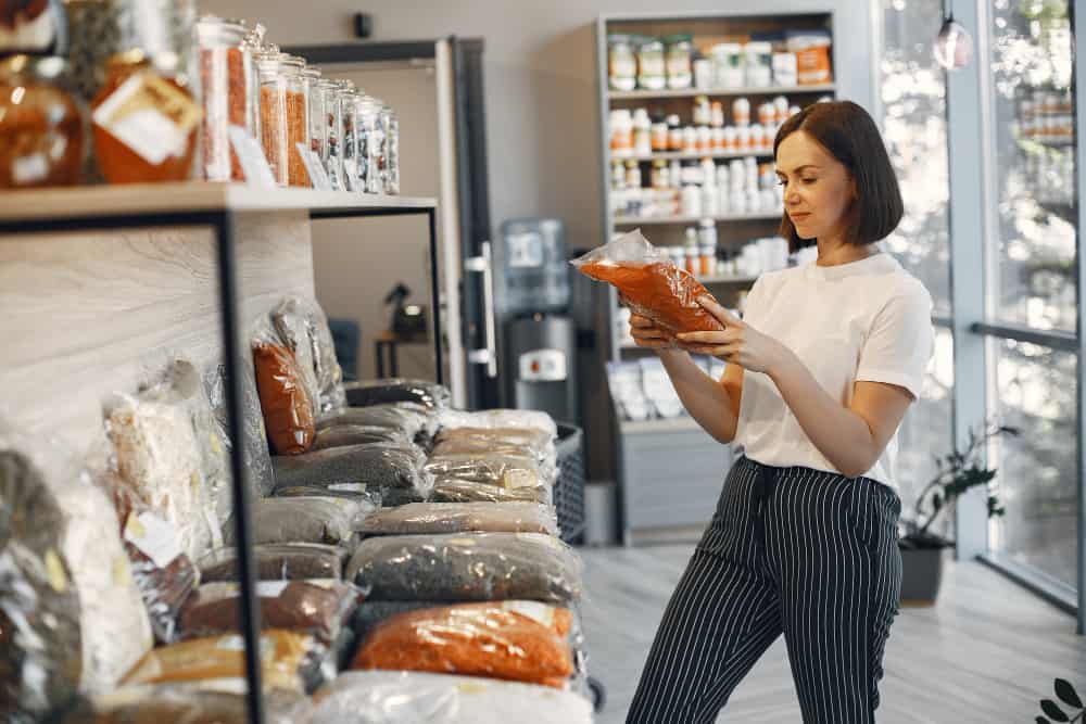 a woman is holding a bag of food in a store .