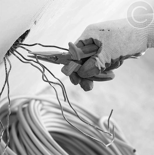 A black and white photo of a person holding pliers