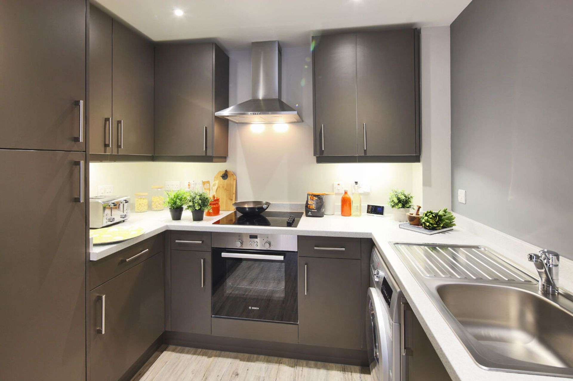 A kitchen with stainless steel appliances and gray cabinets.