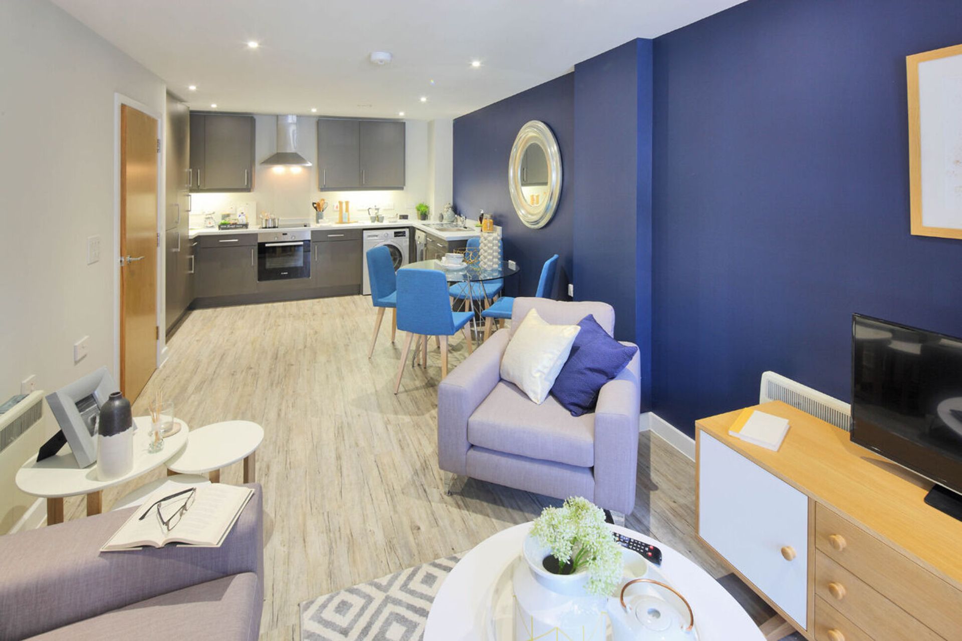 A living room with a couch, chair, table and television.
