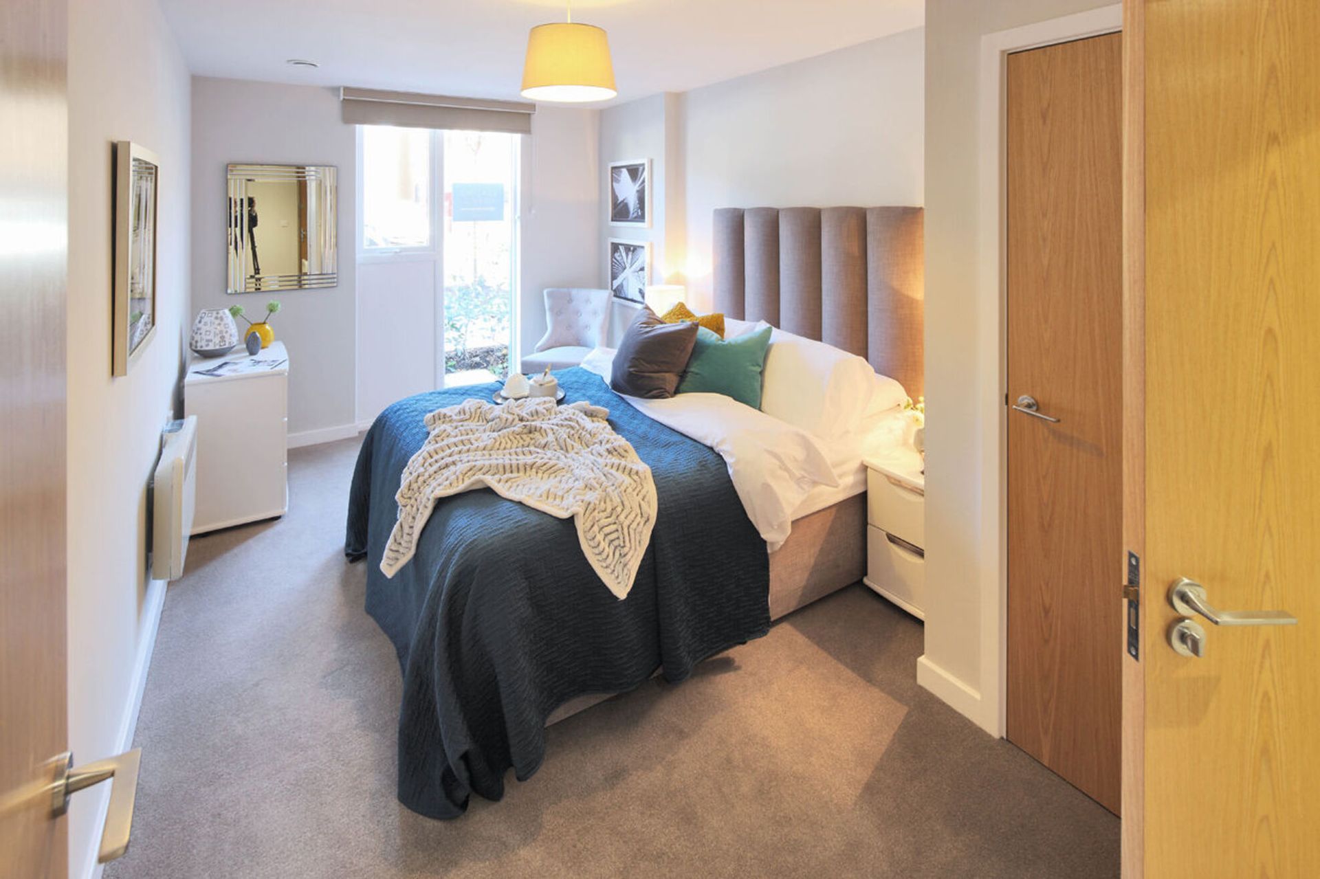 A bedroom with a large bed and a sliding glass door.