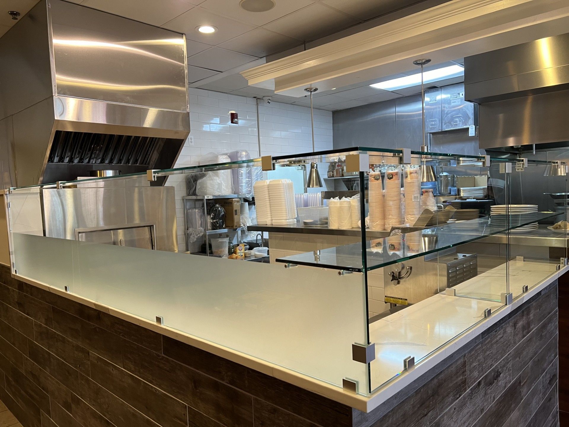 Restaurant kitchen with stainless steel appliances and glass sneeze guards. Plymouth MI