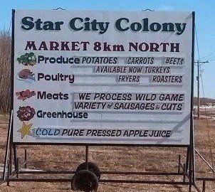 A Star City Colony road sign lists produce, poultry, meats, and greenhouse products available 8km north.