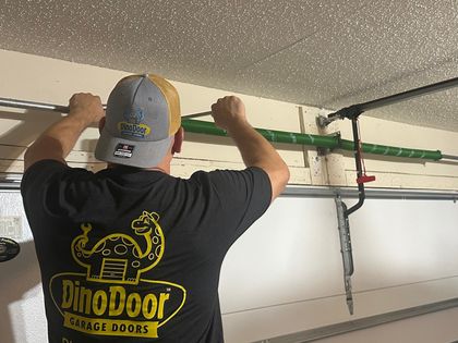 Image of a Dino Door technician working on a garage door repair