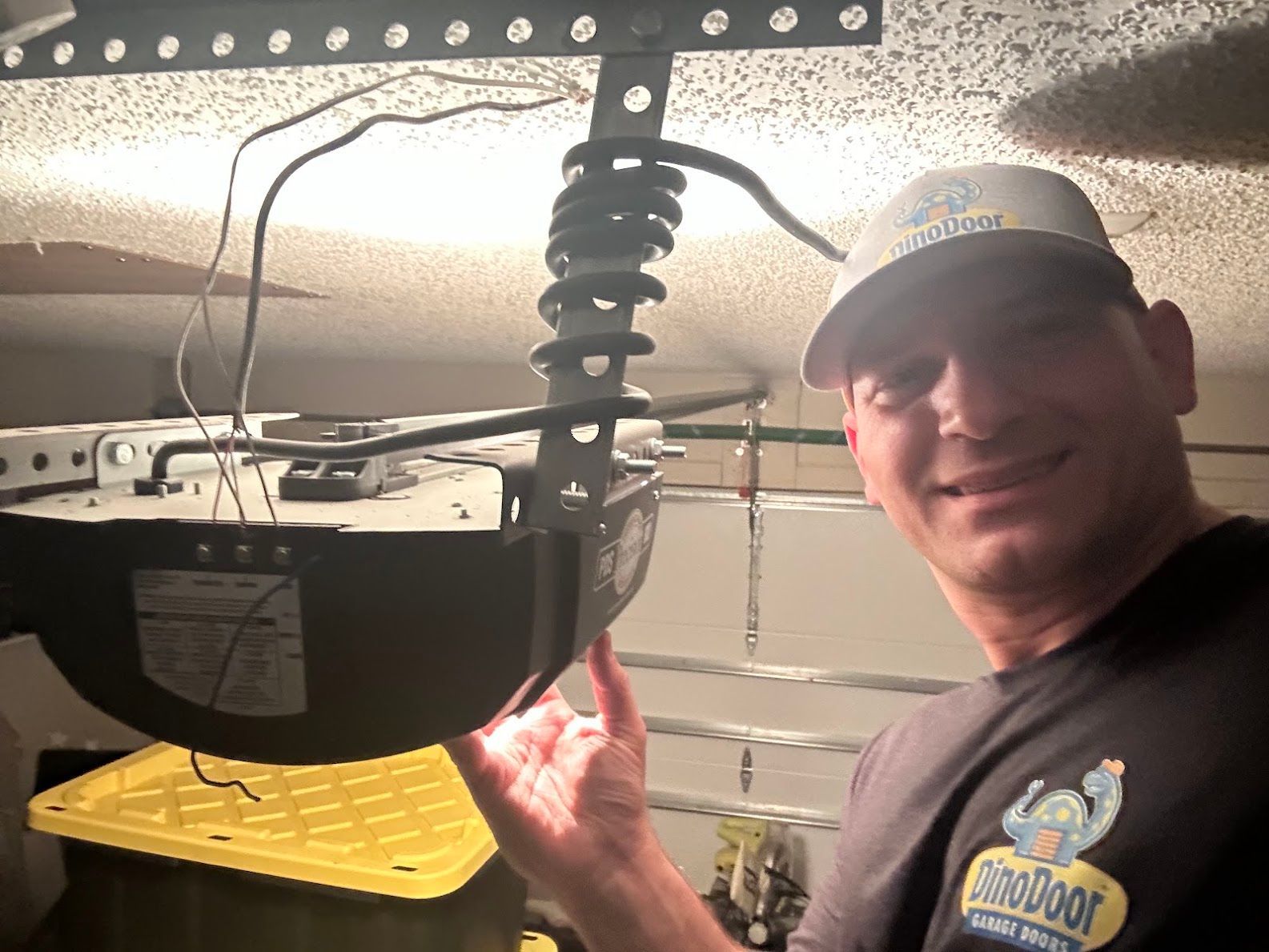 Image of a Dino Door technician working on a garage door opener repair