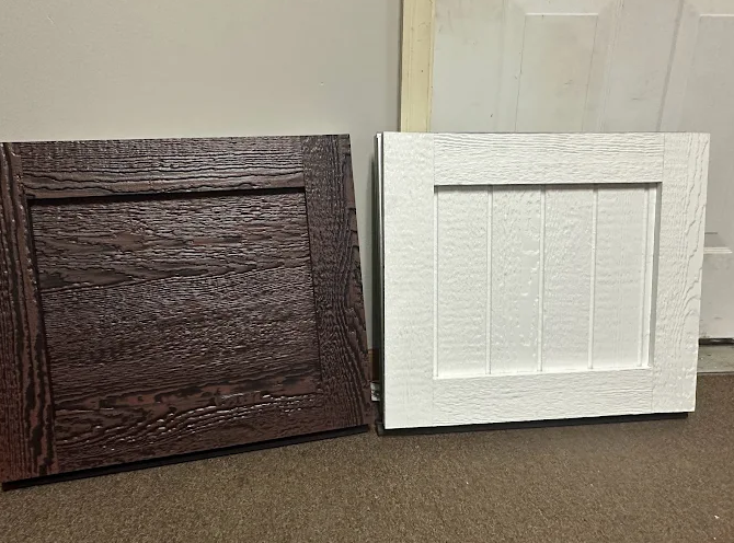 Two small square decorative panels, one dark brown and one white, leaning against a wall.