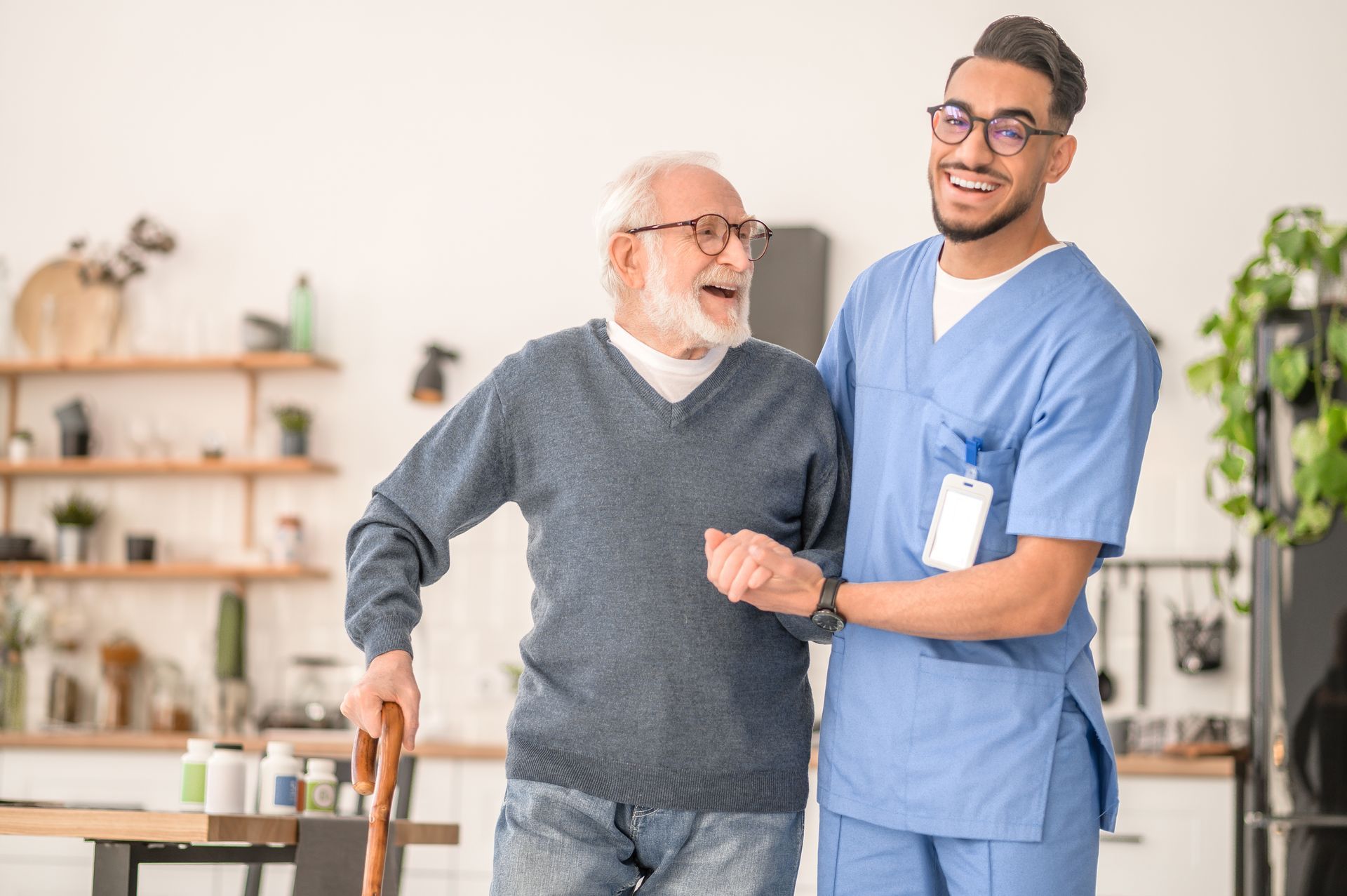 A nurse is helping an elderly man walk with a cane.